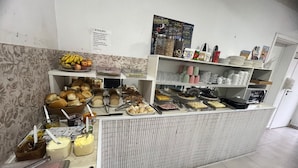 Un área de bufé con diversos alimentos y utensilios.