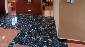 En rymlig lobby med ett marmorgolv, en platt-TV som är monterad på väggen och en affisch på väggen.