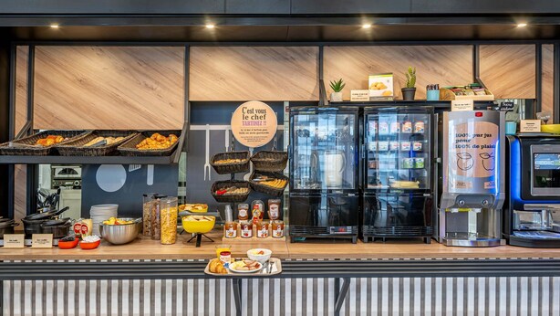 A breakfast buffet with various food items, a coffee machine, and a refrigerator. - B&B HOTEL Bordeaux Bassins à flot (Bordeaux)
