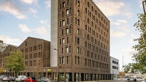 A multi-story hotel with a modern brick facade, large windows, and a visible entrance with a sign. - B&B HOTEL Bordeaux Bassins à flot (Bordeaux)