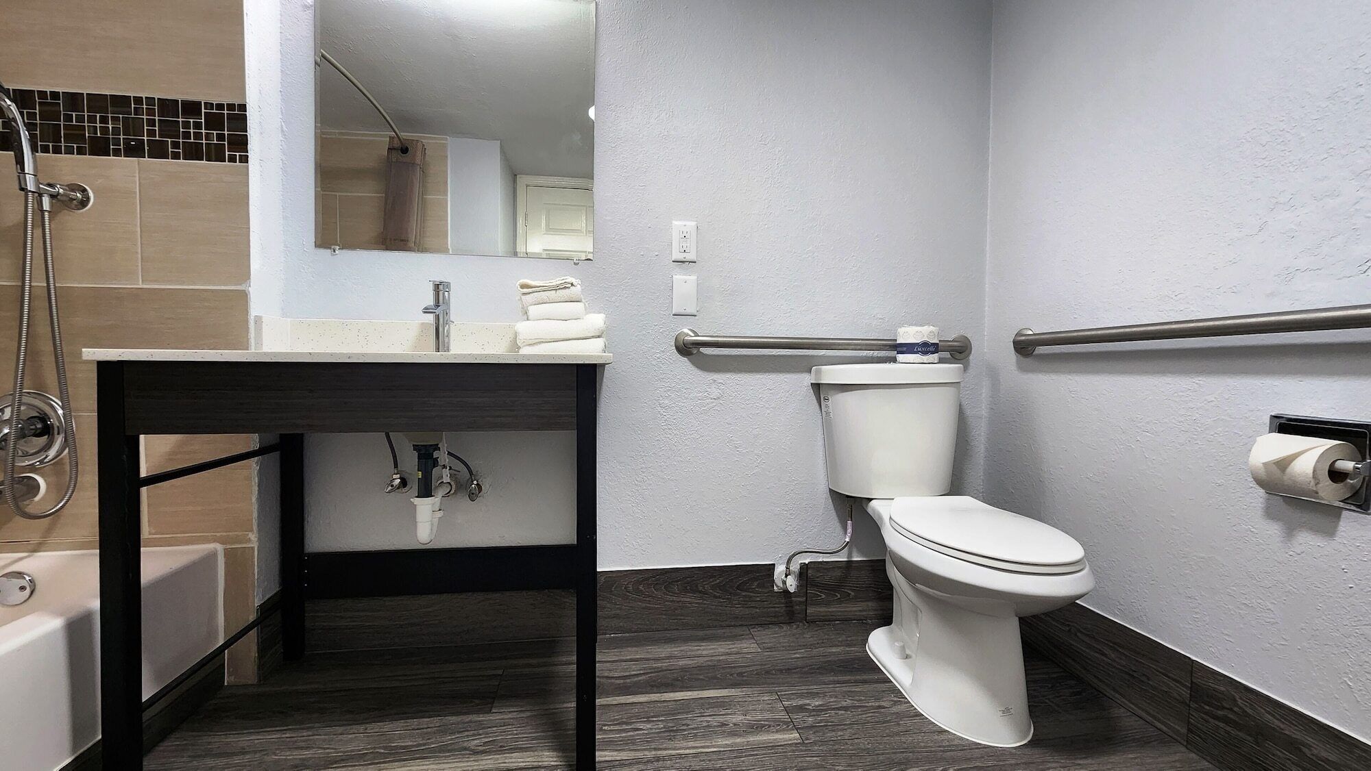 A modern bathroom with a sink, toilet, and shower.