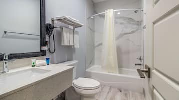 Un baño con lavamanos, inodoro y ducha.