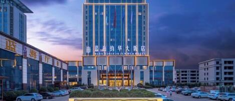 Hotel entrance with a prominent sign featuring the hotel's name in English and Chinese.