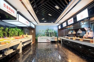 A restaurant interior with a black marble floor, a central poster, and a counter with food items.