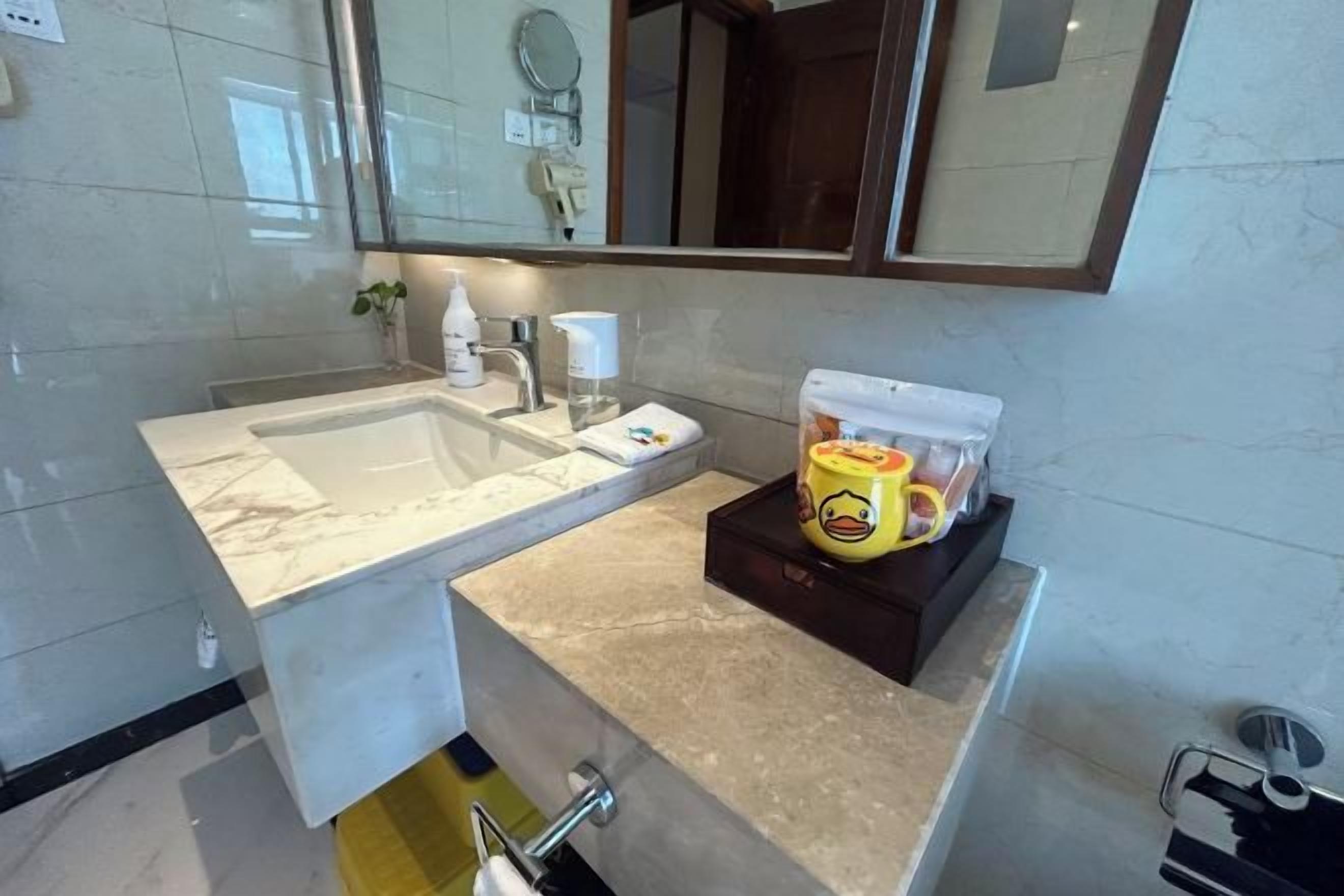 A bathroom with a sink, mirror, and toiletries.