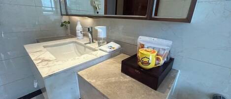 A bathroom with a sink, mirror, and toiletries.