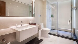 A modern bathroom with a large mirror, a rectangular sink, a toilet, and a glass-enclosed shower. - Blue Horizon Jun Hua Hotel (Fei County)