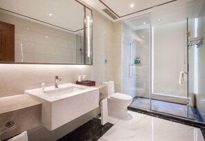 A modern bathroom with a large mirror, a rectangular sink, a toilet, and a glass-enclosed shower. - Blue Horizon Jun Hua Hotel (Fei County)
