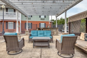 An outdoor patio area with wicker furniture, a table, and a barbecue grill. - SureStay Hotel by Best Western Tuscaloosa Southeast (Tuscaloosa)