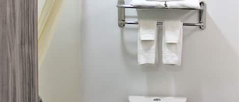 A bathroom with a toilet, a towel rack, and a shower curtain.