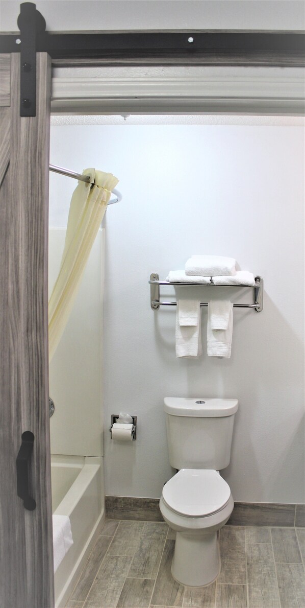 Un baño con inodoro, toallero y cortina de ducha.