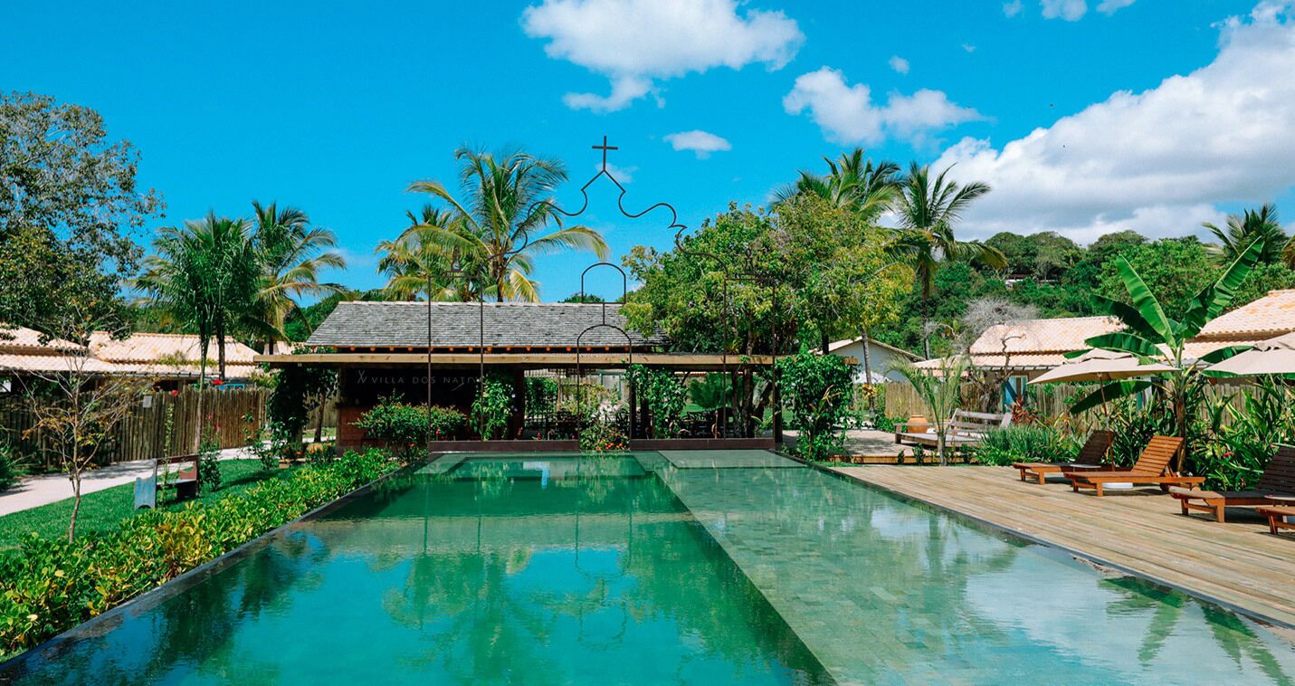 Una piscina al aire libre, sombrillas, sillones reclinables de piscina