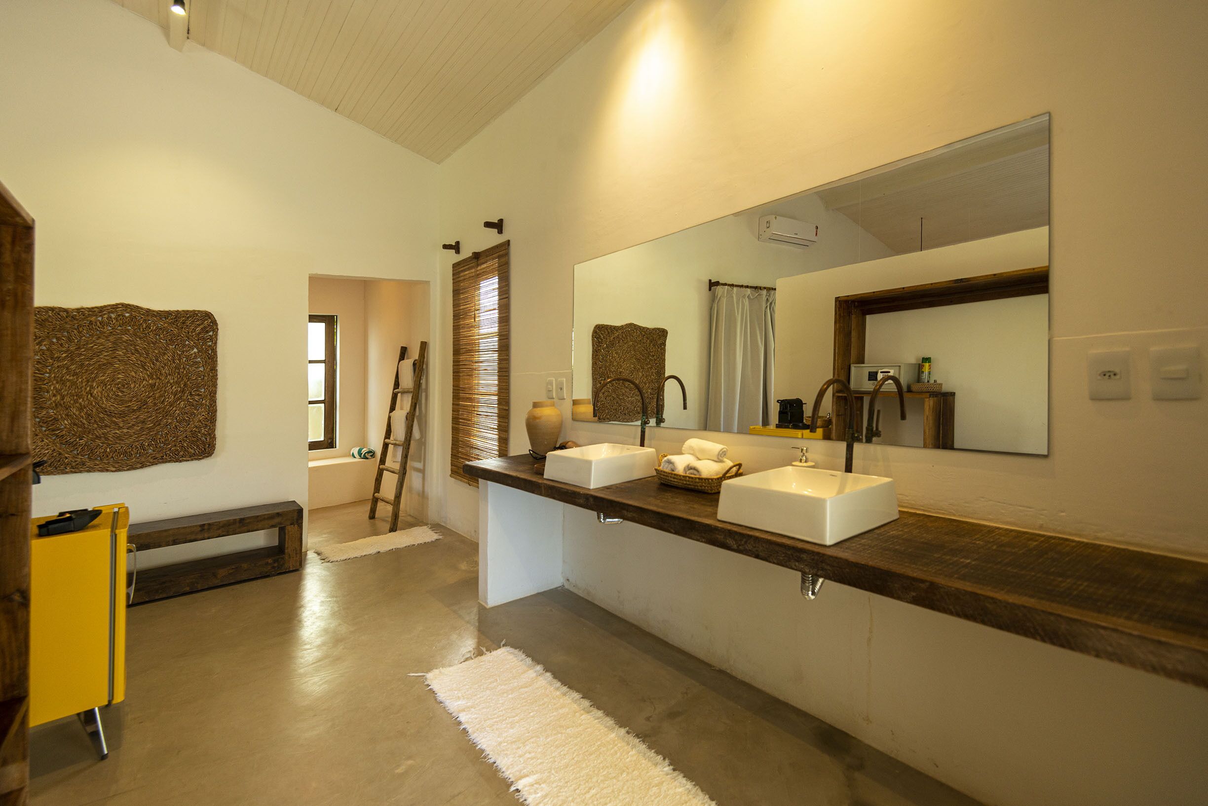 Un baño moderno con un espejo grande, dos lavamanos y un mueble de tocador de madera.