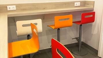 Ein Zimmer mit zwei Tischen und zwei Stühlen, jeweils in unterschiedlichen Farbgestaltungen.