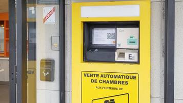 An ATM machine with a yellow sign indicating it is for automatic room sales.