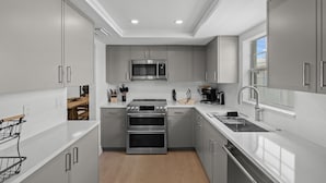 Una cocina moderna con electrodomésticos de acero inoxidable, un horno doble y un microondas.
