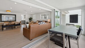 Un interior moderno con comedor, sofá y una mesa con sillas.