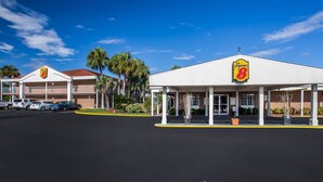 Un motel Super 8 amb zona de pàrquing coberta i façana de maó.