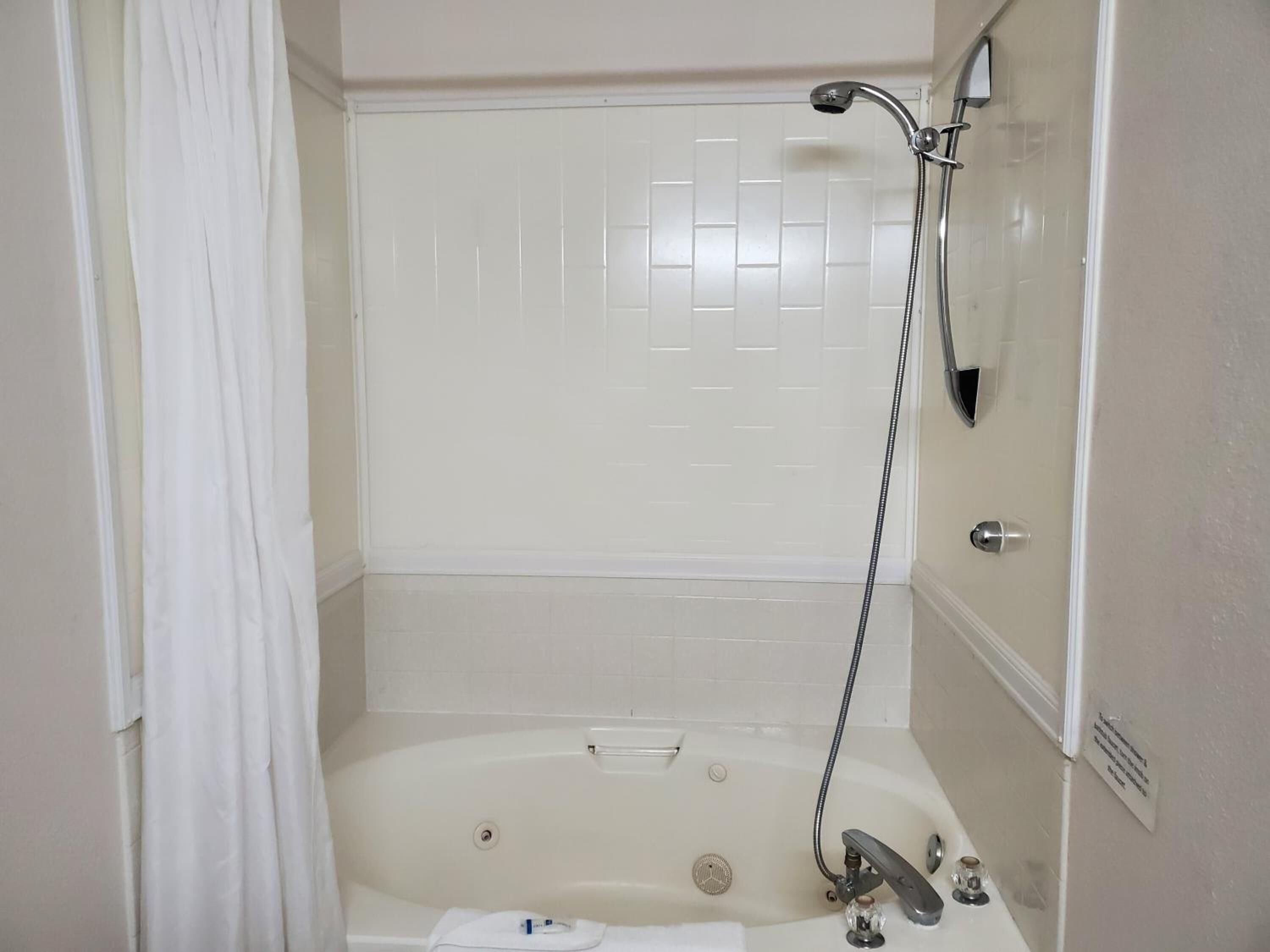 deluxe room, 1 king bed | bathroom | combined shower/bathtub, hair dryer, towels