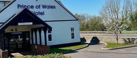 Het uiterlijk van het Prince of Wales Hotel, met een duidelijke ingang en een bord waarop de naam van het hotel staat.