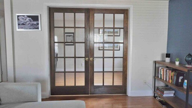 A room with a wooden door, a bookshelf, and a framed picture on the wall. - Housepitality - Top Choice Flat - Great Location (Columbus)