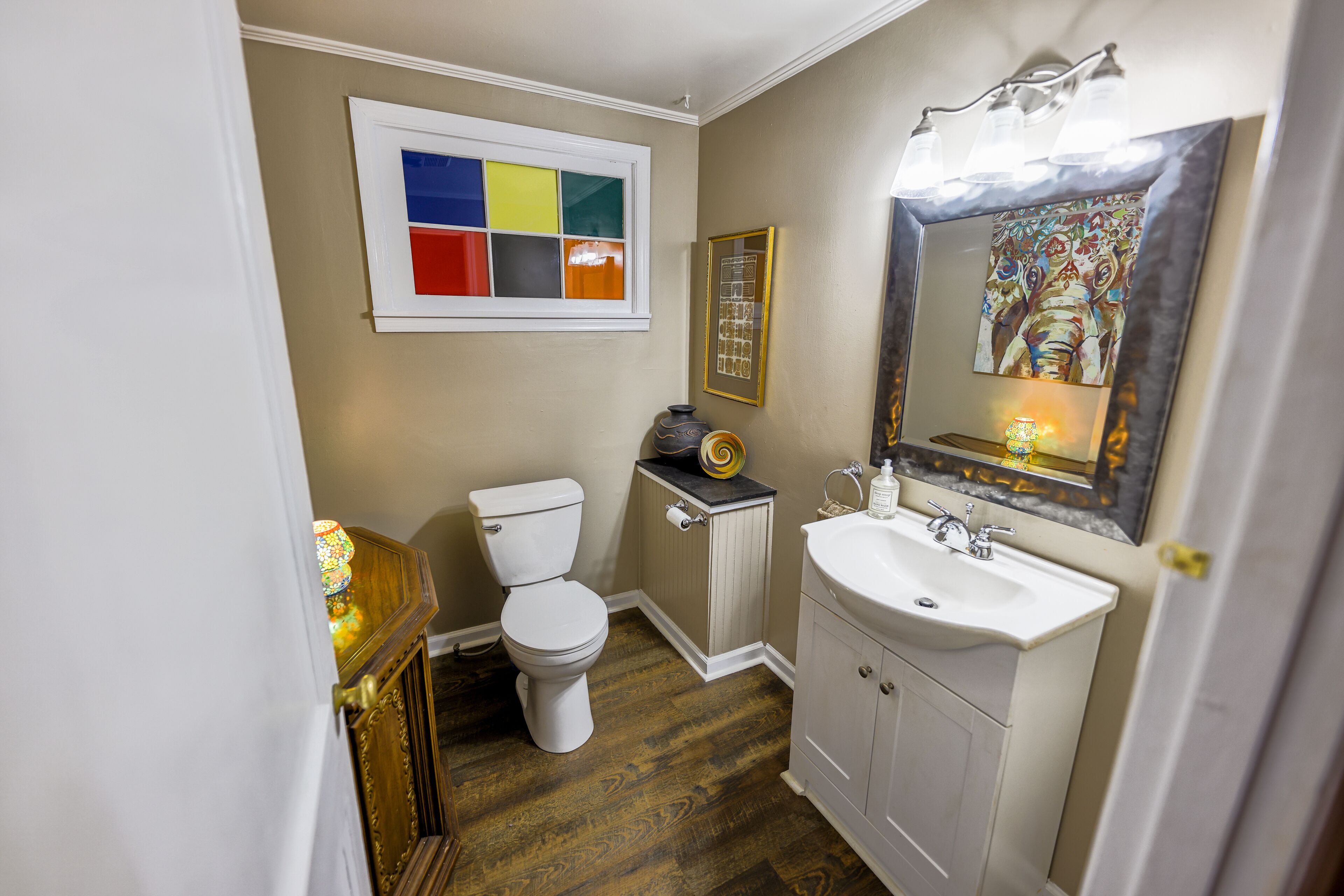 Une salle de bain avec des toilettes, un lavabo et un miroir.