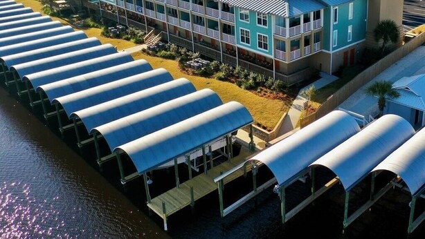 Een hotel aan de kust met meerlaagsgebouwen, een overdekte steiger en uitzicht op de oceaan.