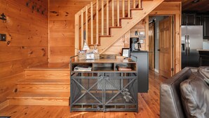Un interior de madera con una escalera, una zona de cocina y un área de descanso.