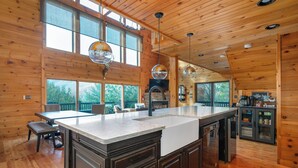 Una cocina amplia con una isla grande, paredes de madera y vistas al exterior.