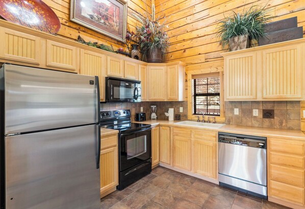 Enjoy cooking in this well-equipped kitchen with a stainless steel refrigerator, microwave, oven, and dishwasher, all integrated into cabinetry.