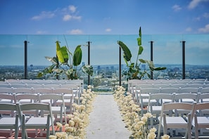 Enjoy breathtaking city views from this elevated space, surrounded by lush greenery and elegant white flowers.