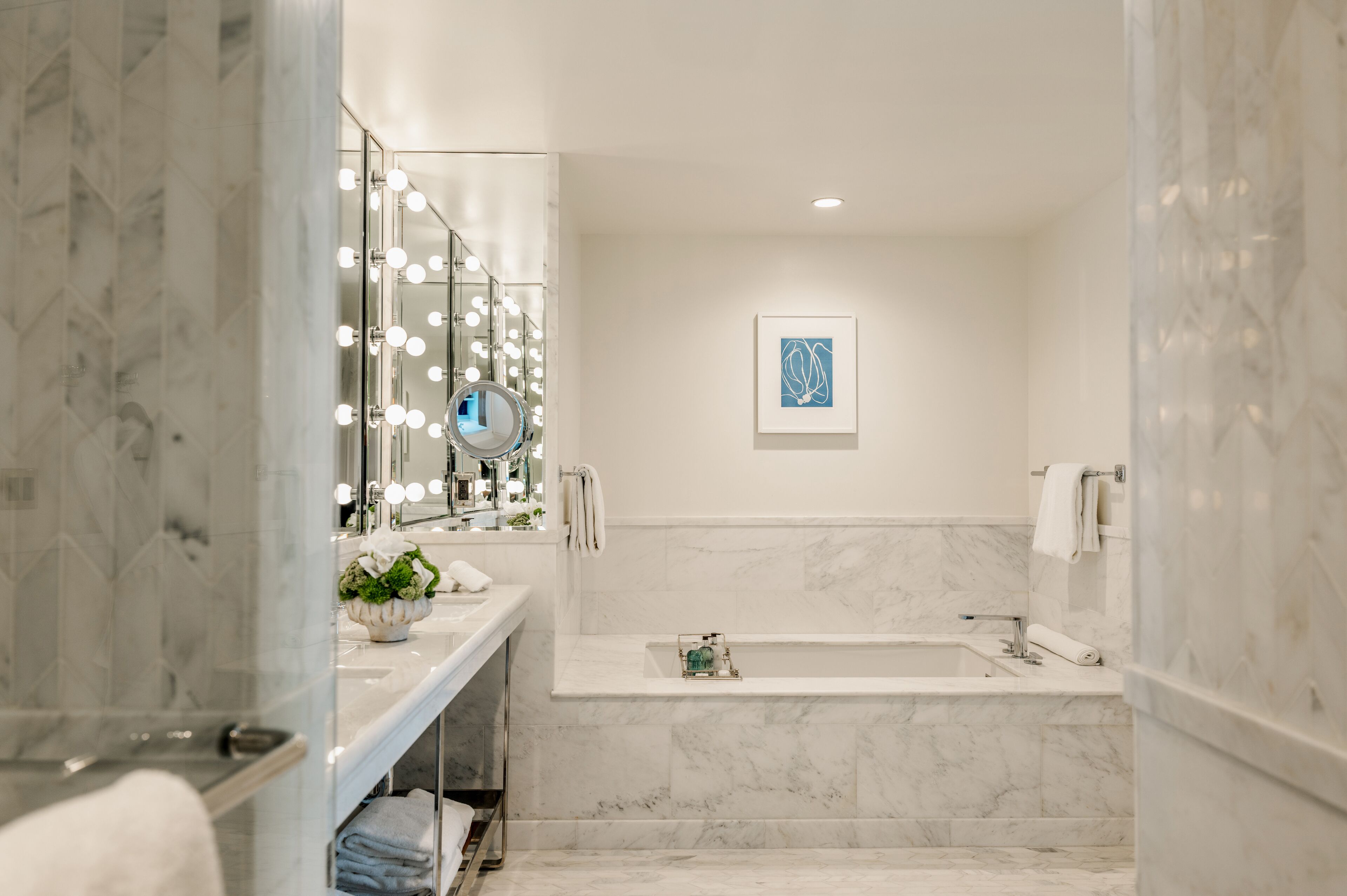 Une salle de bain moderne avec un grand miroir, un meuble-lavabo et une baignoire.