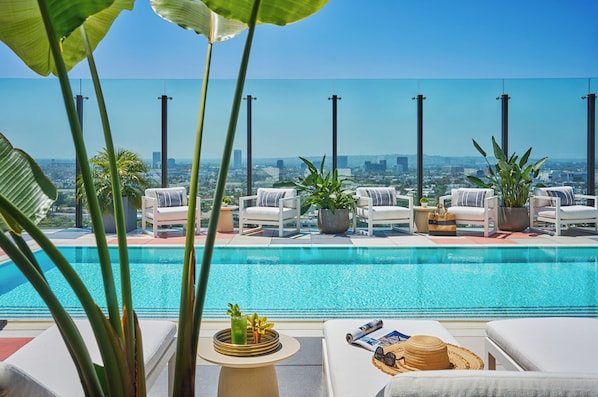 Piscine extérieure, parasols de plage, chaises longues