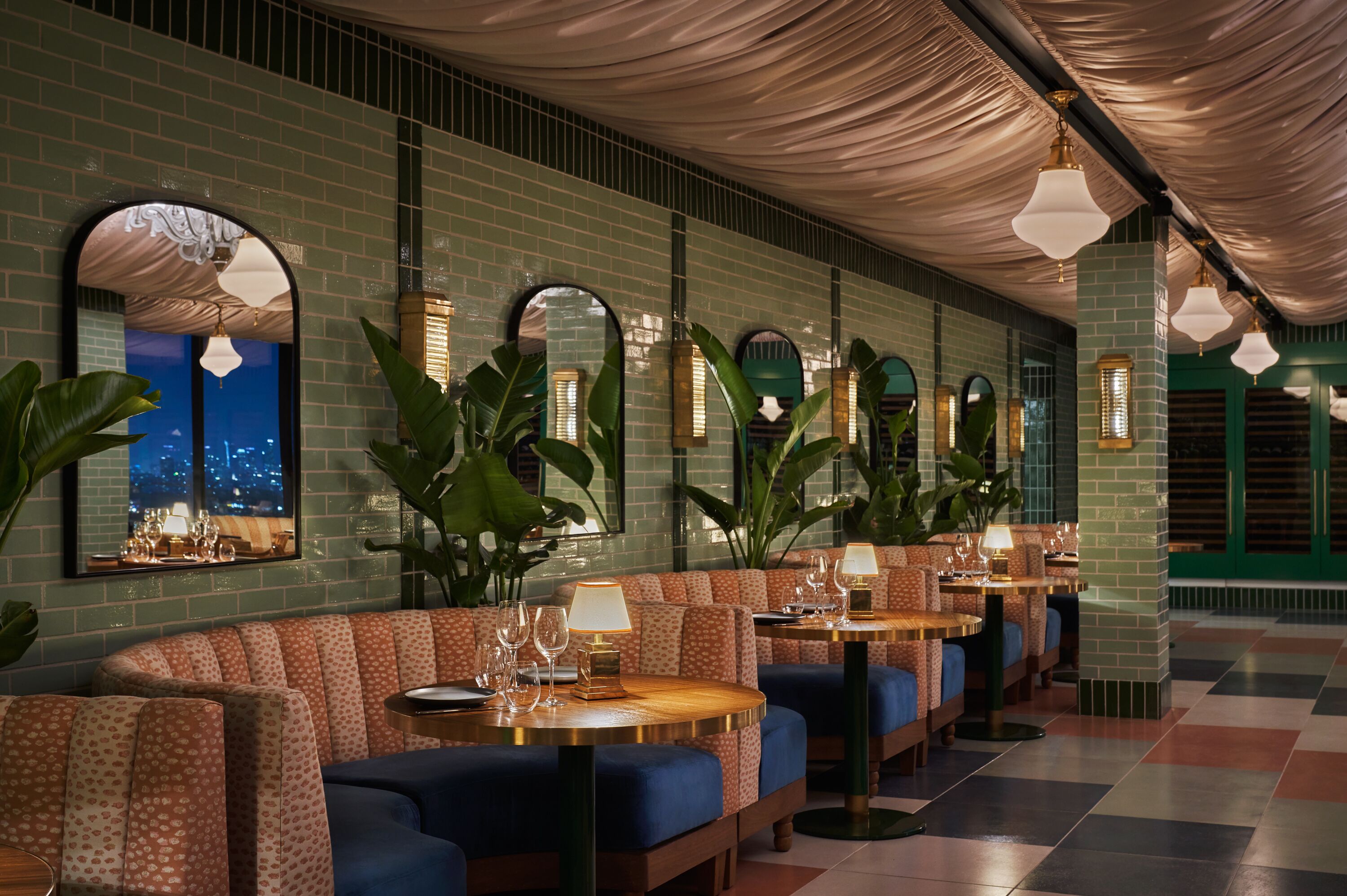 A restaurant with booths, tables, and hanging lights.