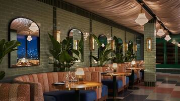 A restaurant with booths, tables, and hanging lights.