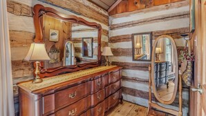 A wooden cabin interior with a dresser, mirrors, and lamps. - Pondview Cabin - pond, log cabin, wifi, screen porch, deck, hiking, king bed (Berkeley Springs)