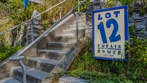 A public house sign for Lot 12, established in 1999, with a stone staircase leading up to it. - Pondview Cabin - pond, log cabin, wifi, screen porch, deck, hiking, king bed (Berkeley Springs)