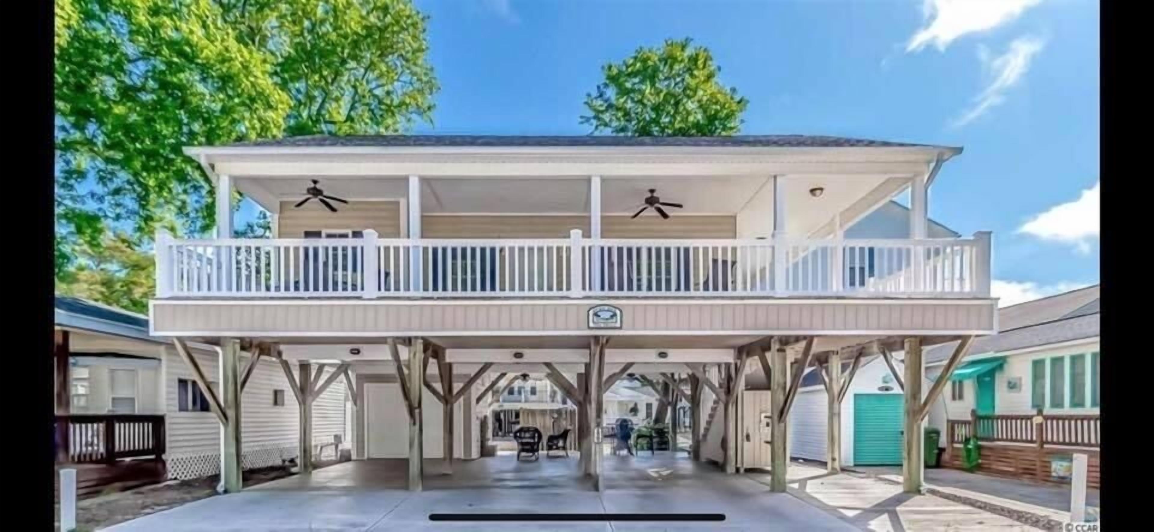 A two-story house with a covered porch and a balcony.