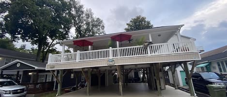 A two-story building with a balcony and a covered area.