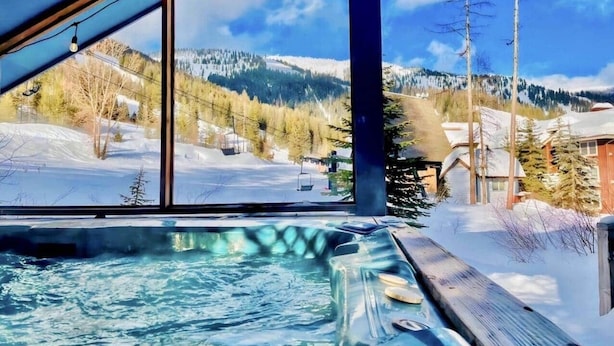 A hot tub with a view of a snowy landscape and mountains. - True Slopeside 7-Bedroom Home: 75ft to Chair, Private Hot Tub, Deck, Sleeps 16 (Whitefish)