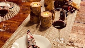 A festive dinner table with candles, a Christmas tree, and seasonal decorations. - True Slopeside 7-Bedroom Home: 75ft to Chair, Private Hot Tub, Deck, Sleeps 16 (Whitefish)