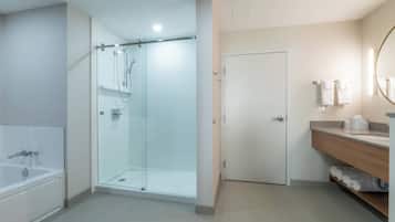 A modern bathroom with a glass-enclosed shower, a bathtub, and a vanity with a mirror.