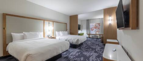 A hotel room with two beds, a desk, a chair, a flat-screen TV, and a large window with curtains.