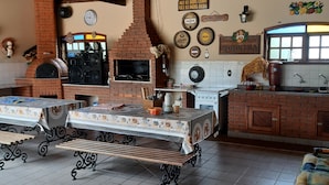 Een keuken met een bakoven, een spoelbak en een eettafel met banken.