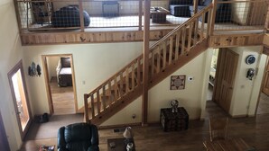 Un vaste espace de vie de style loft, doté d’un escalier en bois, de hauts plafonds et d’une mezzanine.
