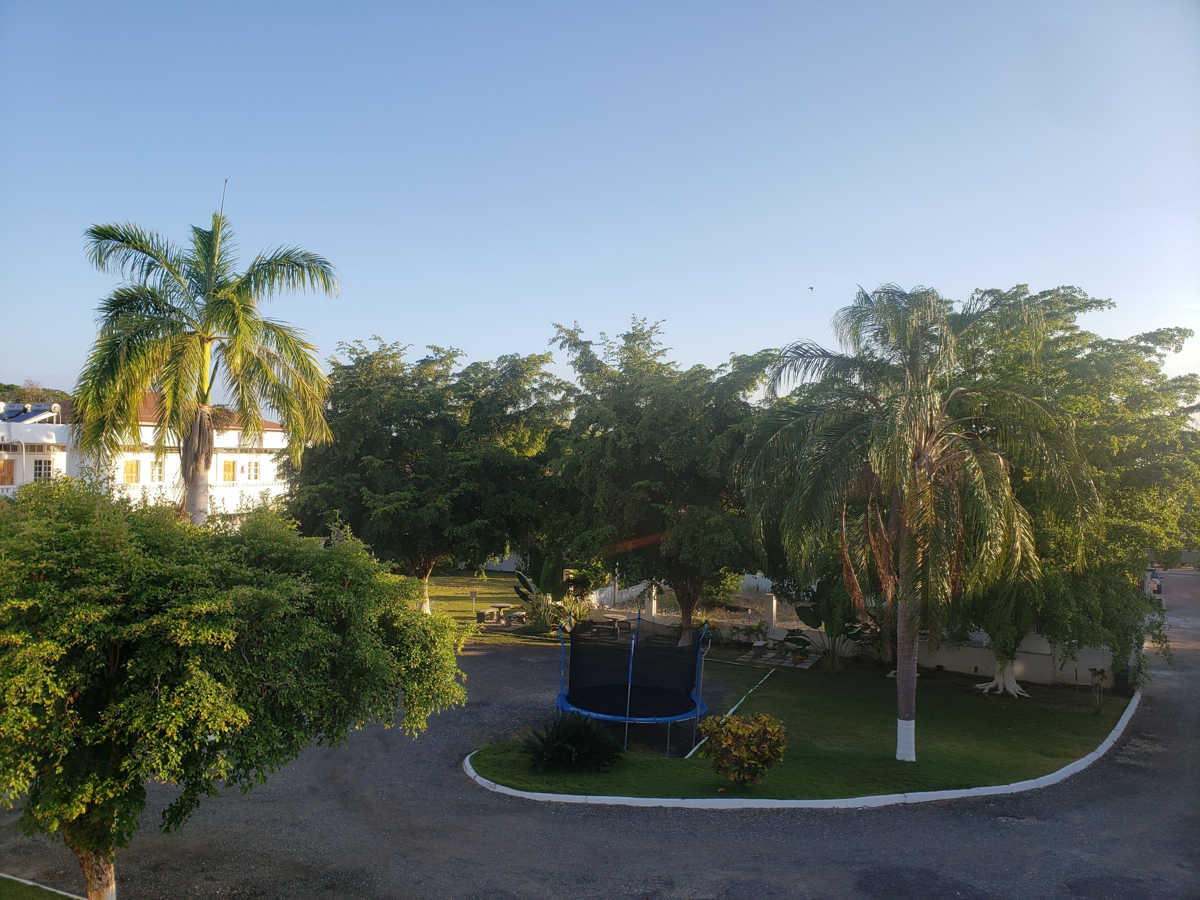 A residential area with a playground, trees, and a building in the background.