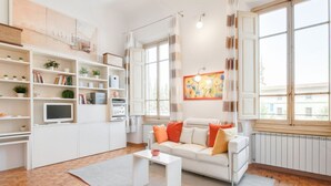 Ein modernes Wohnzimmer mit einem weißen Sofa, einem Couchtisch und einem Bücherregal.