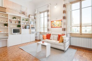Ein modernes Wohnzimmer mit einem weißen Sofa, einem Couchtisch und einem Bücherregal.