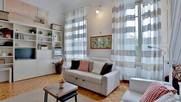 Ein modernes Wohnzimmer mit einer Couch, einem Couchtisch und einem Bücherregal.