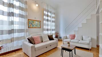 Ein modernes Wohnzimmer mit einer Couch, einem Couchtisch und einer Treppe.